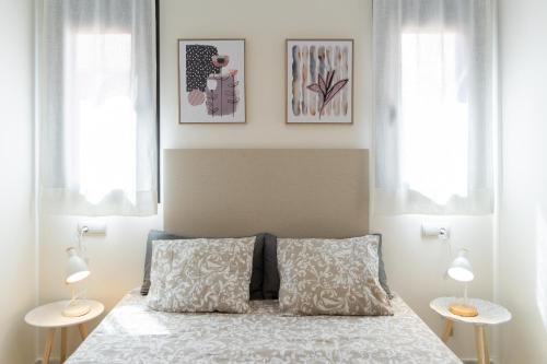 una camera da letto con un letto con due tavoli e due lampade di Atico Gran Esperanza a Fuengirola