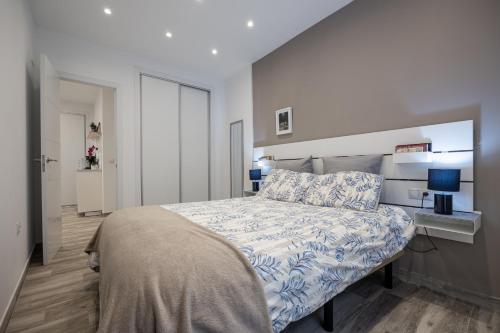 a bedroom with a bed with a blue and white comforter at Oviedo Puerto in Fuengirola