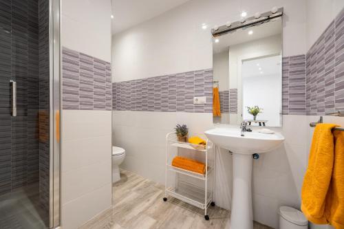 a bathroom with a sink and a toilet and a mirror at Oviedo Puerto in Fuengirola