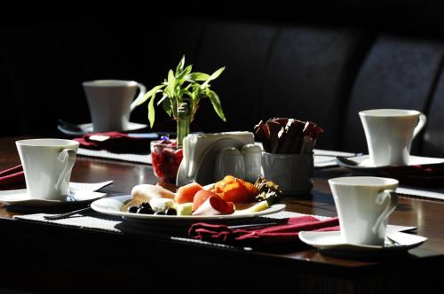 a table with a plate of food and two cups at Hotel Monec in Ankara