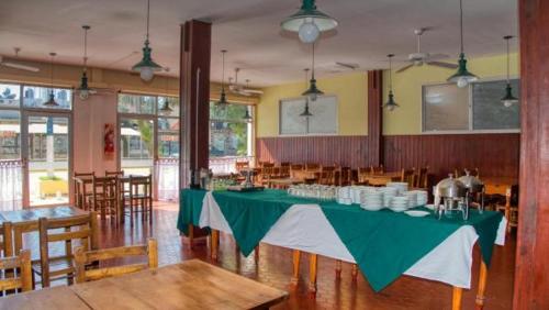 a dining room with a green table in a restaurant at Costa Clara Hotel in Santa Clara del Mar