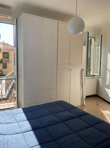 a bedroom with a blue bed and a large window at Casa Flora in Finale Ligure