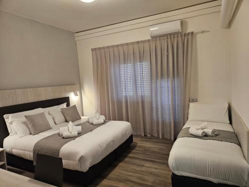 a hotel room with two beds and a window at Il Romitello in Rome
