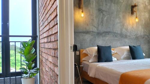 a bedroom with a bed and a brick wall at Silvan Garden Cameron Highlands in Tanah Rata