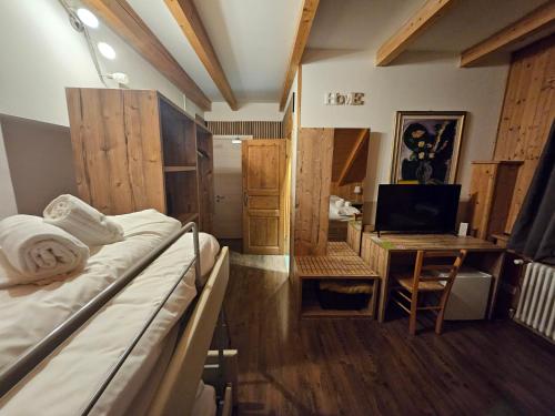 a room with a bed and a desk with a computer at Hotel Tarvisio Four Seasons in Tarvisio