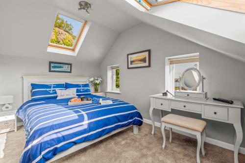 a bedroom with a bed and a desk and a mirror at Seascape in Torpoint