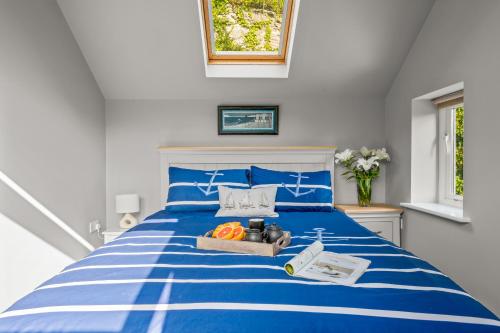 a blue and white bed with a box of oranges on it at Seascape in Torpoint