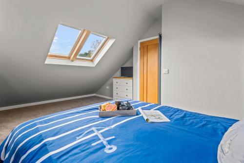 a bedroom with a blue bed with a window at Seascape in Torpoint