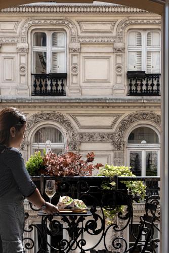 a woman standing in front of a table with a plate of food at Grand Pigalle Experimental in Paris
