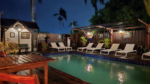 a swimming pool with lounge chairs and a table and a table and a tablektop at Greenheart Boutique Hotel in Paramaribo