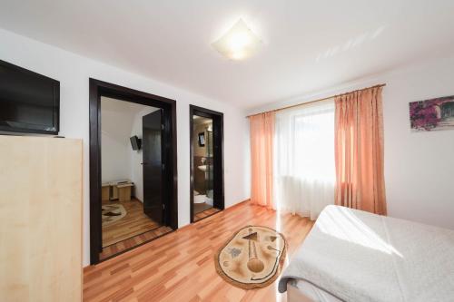 a living room with a bed and a large window at Casa Dintre Vai in Şimon
