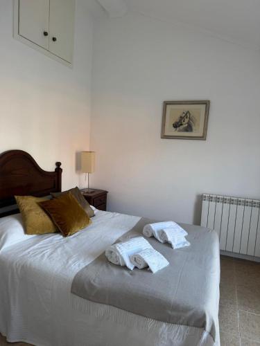 a bedroom with a bed with towels on it at Quinta do Cutato - Piscina Guest House in Santo Estêvão
