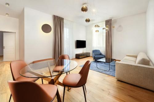 a living room with a glass table and chairs at Apartmány Kuszmannov bazár in Vysoké Tatry
