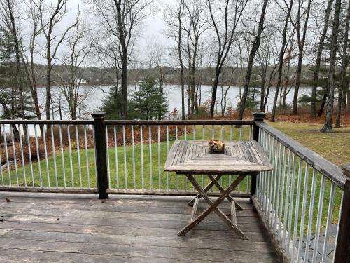 a picnic table on a wooden deck with a fence at Fresh Pond East in Plymouth