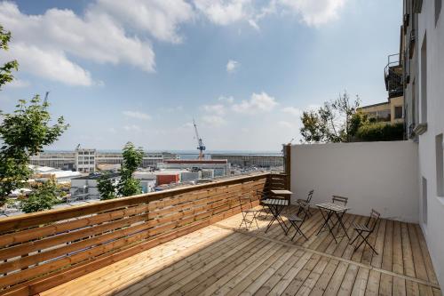 Elle comprend un balcon avec deux chaises et un mur blanc. dans l'établissement Pokou, à Brest