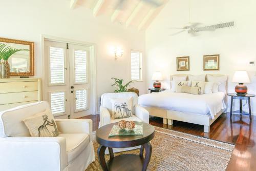 a bedroom with a bed and a couch and a table at The Inn at English Harbour in English Harbour Town