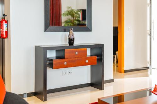 a table with a mirror and a vase on it at Villa Rodrigues by Amazing Madeira in Ponta do Sol