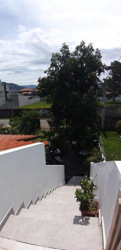 a white stairway with two potted plants on it at Varanda do Campeche in Florianópolis