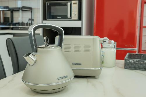 a white tea kettle on a counter in a kitchen at The Stay Christmas Yusuam in Jeju