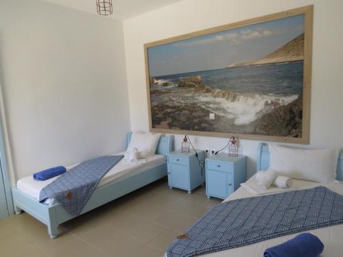 a bedroom with two beds and a painting on the wall at Blue Beach Villas Apartments in Stavros
