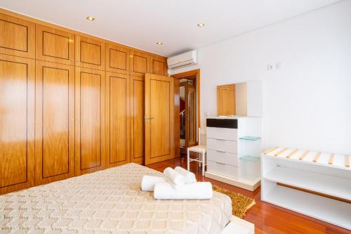 a bedroom with a bed and wooden cabinets at Villa Rodrigues by Amazing Madeira in Ponta do Sol