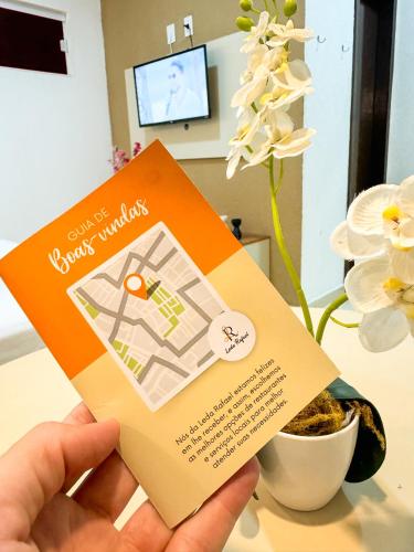 a person holding up a ticket to a hotel room at Hotel Leda Rafael in João Câmara