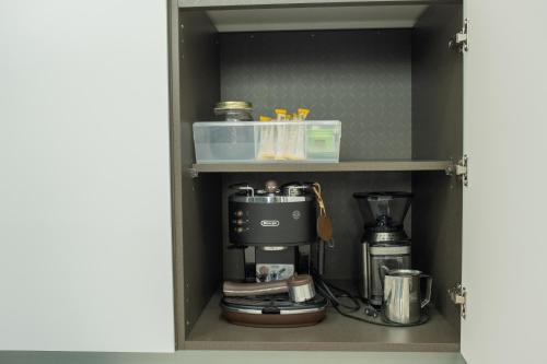 a coffee maker on a shelf in a cupboard at The Stay Christmas Yusuam in Jeju