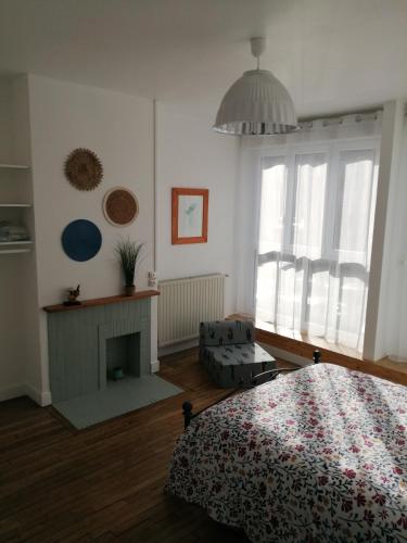 une chambre avec un lit et une cheminée dans l'établissement L'Héritage, à Abbeville