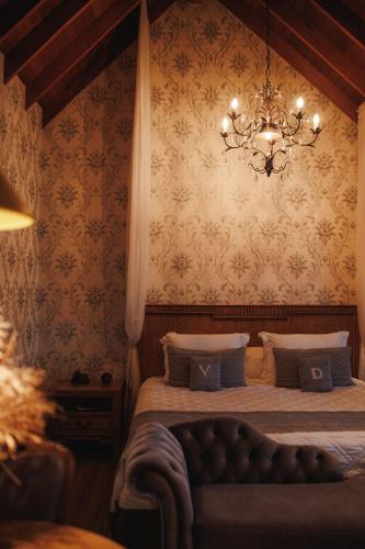 a bedroom with a bed and a chandelier at Hotel Valle Dincanto in Gramado