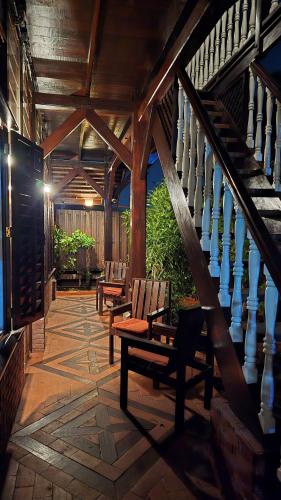 a porch with two chairs and a staircase at Greenheart Boutique Hotel in Paramaribo