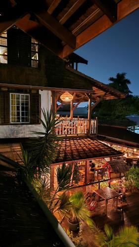 an outdoor patio with a deck with tables and chairs at Greenheart Boutique Hotel in Paramaribo