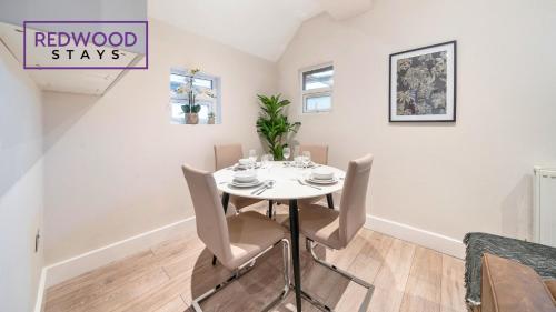 a white dining room with a white table and chairs at Newly Refurbished Everest Lodge Serviced Apartments for Contractors & Families, FREE WiFi & Netflix by REDWOOD STAYS in Farnborough