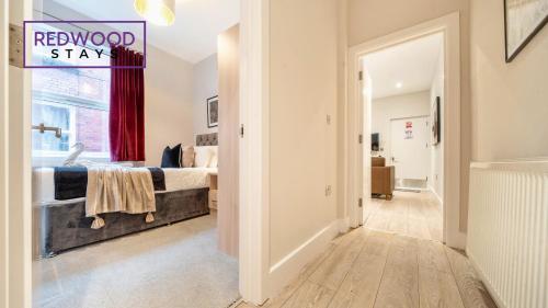 a bedroom with a bed and a sign that reads renovated stay at Newly Refurbished Everest Lodge Serviced Apartments for Contractors & Families, FREE WiFi & Netflix by REDWOOD STAYS in Farnborough