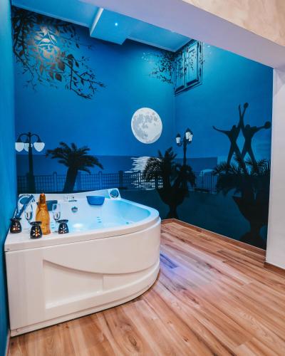 eine Badewanne in einem Zimmer mit blauen Wänden in der Unterkunft Moon Suite - Taranto Centro - Vasca Idromassaggio in Taranto