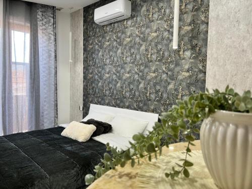 a bedroom with a white bed and a wall at Pompei Sunday Estate Exclusive Apartaments in Pompei
