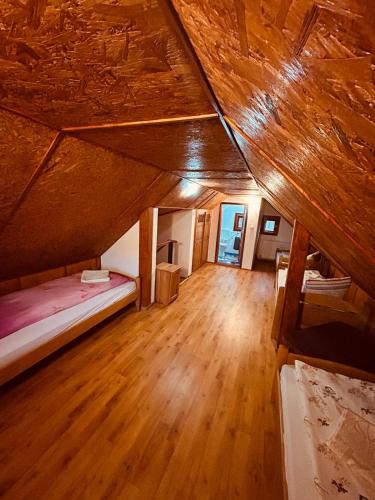an attic room with a bed and a wooden floor at ViiLa Cabanuta in Filia