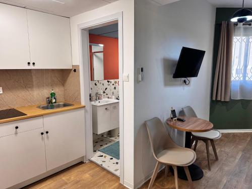 a kitchen with a sink and a table with chairs at Modern Studio 4 private Kitchenette and Bathroom in Limassol