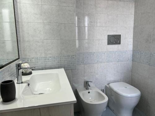 a white bathroom with a sink and a toilet at Pompei Sunday Estate Exclusive Apartaments in Pompei