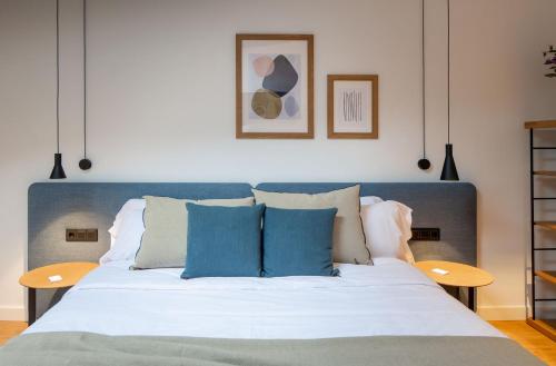 a bedroom with a large bed with blue pillows at EtxeAundi Hotel Boutique in Oñate