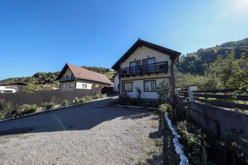 a house on a hill with a road leading to it at Casa Dintre Vai in Şimon