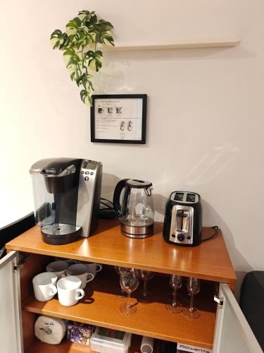 a shelf with a coffee maker and a toaster at Cozy Commercial Oasis - Private Entrance Studio in Vancouver
