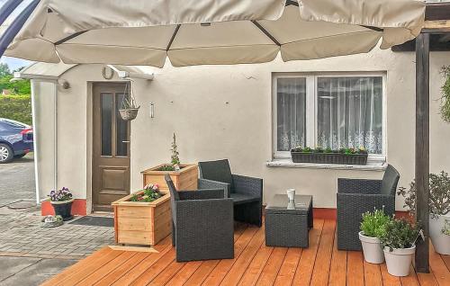 a patio with chairs and an umbrella in front of a house at Ferienwohnung Altenkirchen in Altenkirchen