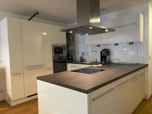 a kitchen with white cabinets and a counter top at Gipfelblick mit Hallenbad und Sauna in Bergen