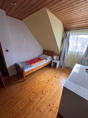 a small bed in a room with a wooden floor at Austria Traveller Hotel Kirchdorf in Kirchdorf an der Krems