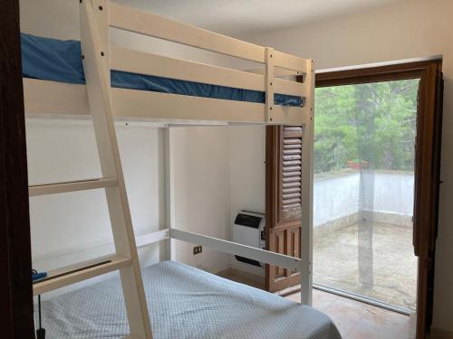 a bunk bed room with a ladder and a window at Noravilla con piscina fra mare e montagne in Mandra Capreria