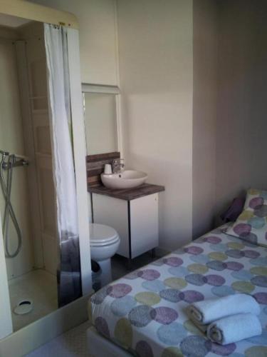 a bathroom with a bed and a sink and a toilet at Auberge Bella Riva in Creysse