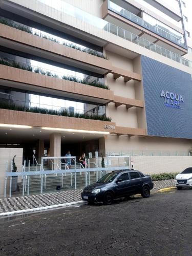 a black car parked in front of a building at Residencial Acquamare in Praia Grande