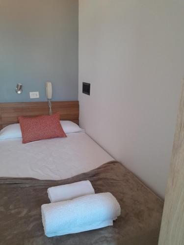 a bedroom with a bed with two pillows on it at Restaurante y Hostal San Paio in Santiago de Compostela