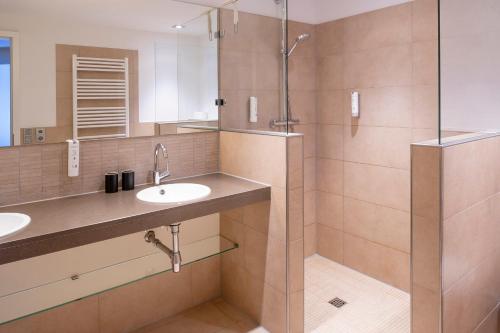 a bathroom with two sinks and a shower at Suitenhotel Idyll Heckenrose in Langeoog