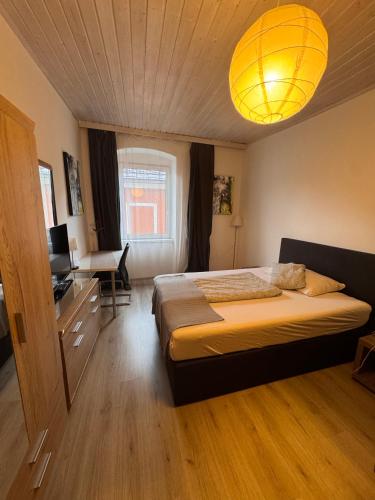 a bedroom with a bed and a chandelier at Austria Traveller Hotel Kirchdorf in Kirchdorf an der Krems
